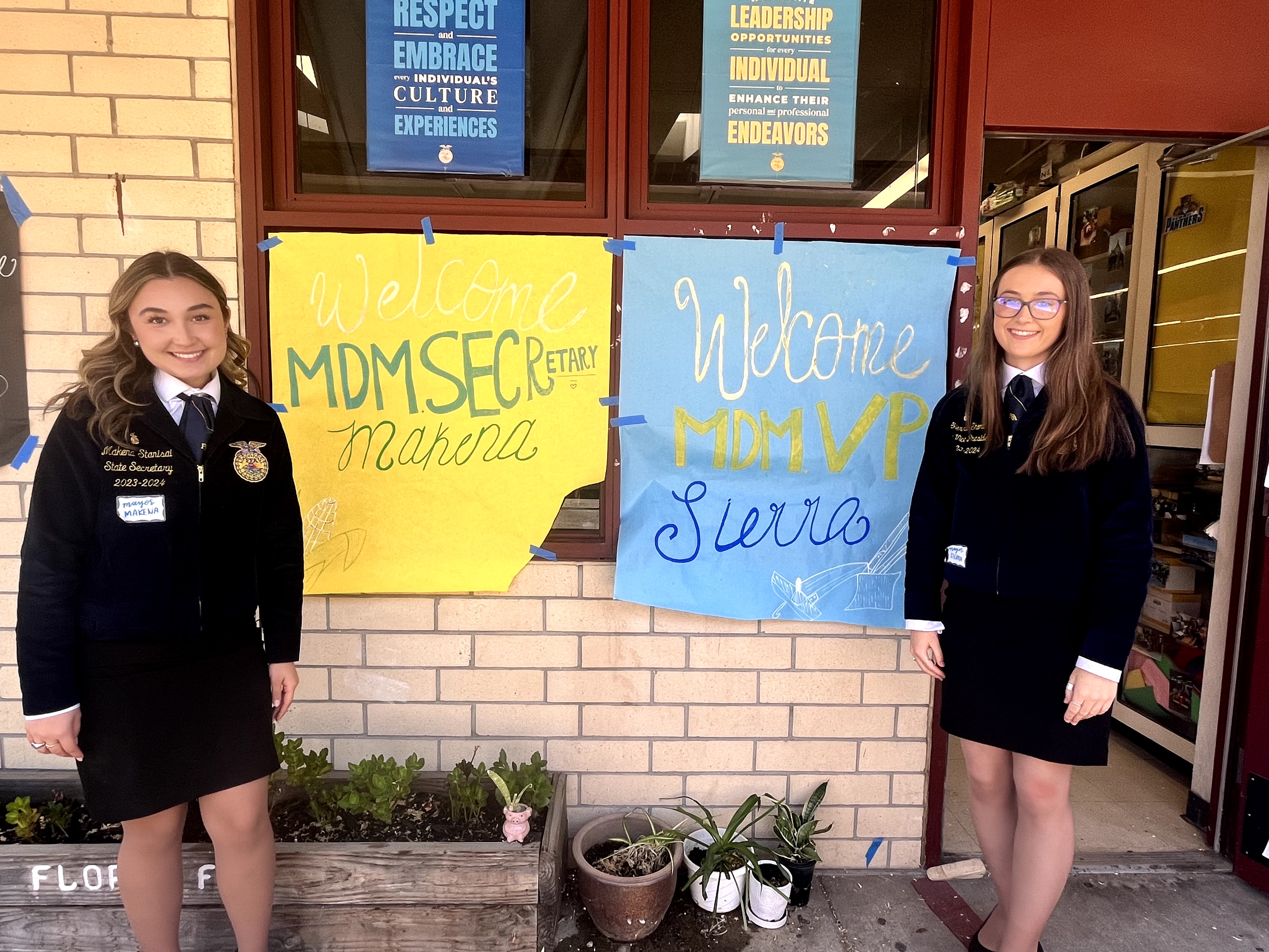 Sierra and Makena with welcome signs